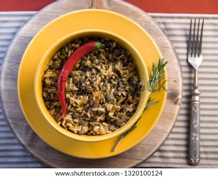 Arabic dish mujadara decorated with rosemary and red pepper