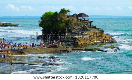 Small human atTanah Lot water temple in Bali island, Indonesia  Royalty-Free Stock Photo #1320117980