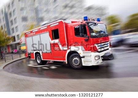 Fire engine driving fast on a road in an emergency Royalty-Free Stock Photo #1320121277