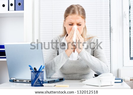 Young business woman sneezing while working in office,Businesswoman having flu Royalty-Free Stock Photo #132012518