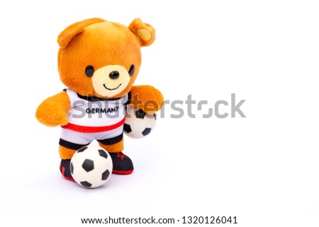 Teddy bear athlete in Germany dressed player with ball isolated on white background.