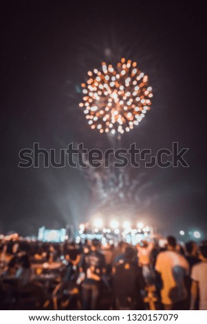 Vertical vintage tone blur image of people in night festival with performance stage on street with bokeh and fireworks for background usage .