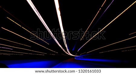 Cars light trails on a curved highway at night. Night traffic trails. Motion blur. Night city road with traffic headlight motion. Cityscape. Light up road by vehicle motion blur. Long exposure
