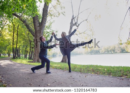 Young happy couple dancing in the autumn park. Sunny day, golden autumn