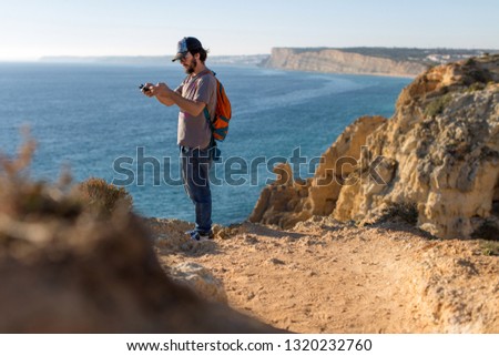 Man taking pictures of ocean landscapes, Ponta da Piedade near Lagos, Algarve, Portugal