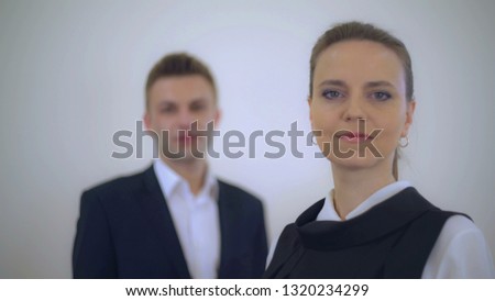 portrait business partners posing looking at the camera. Adult businessman and businesswoman wearing formal clothing white and black color. Focus defocus.