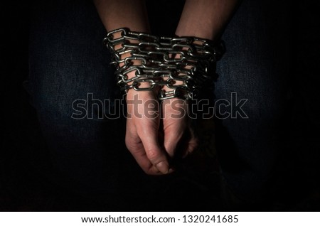 Hands chained in chains isolated on black background