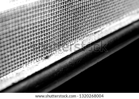 Black and white picture of a Window pane with steel grills.
