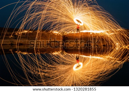 Couple Swirl Steel Wool light Photography over the rock and water at night Sam Phan Bok.