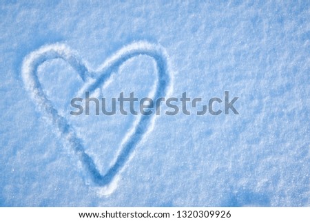 hand drawn heart shape in the fresh snow