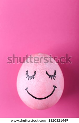Pink egg with painted smiles. Happy Easter, concept greeting card design.