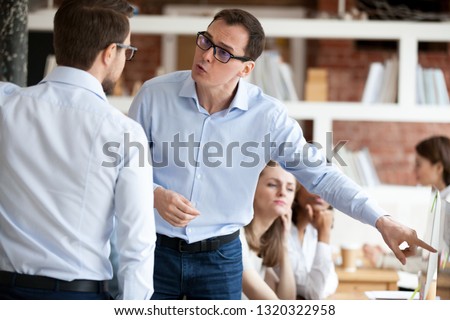 Indignant men colleagues quarrelling in shared office, having different opinion and disagreements arguing at work. Mad millennial employee accusing business partner disputing at coworking modern room Royalty-Free Stock Photo #1320322958