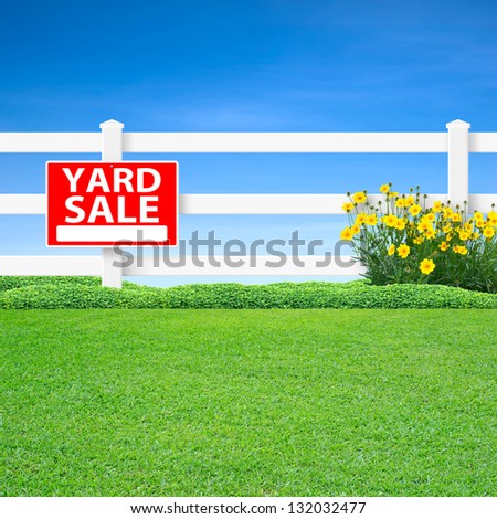 Yard sale sign and long white fence with green grass