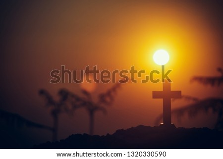 Christian cross standing with light sunset background. christian silhouette concept.