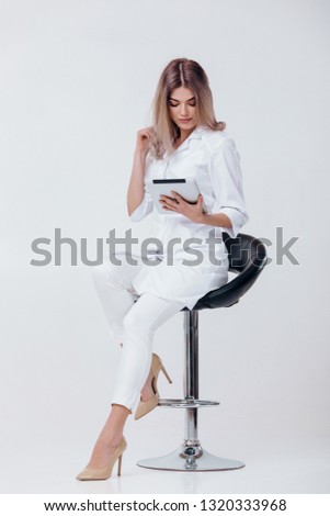 beautiful young doctor in white coat using digital tablet