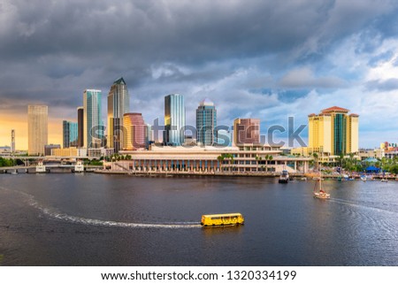 Tampa, Florida, USA downtown skyline on the bay at dusk with water traffic.