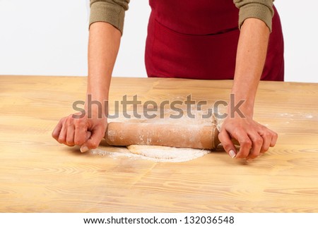 Flattening dough with a wooden rolling pin