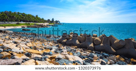 concrete material breakwater on the seashore protects the bay from the hurricane. Tropics good sunny weather, Vietnam, South China Sea