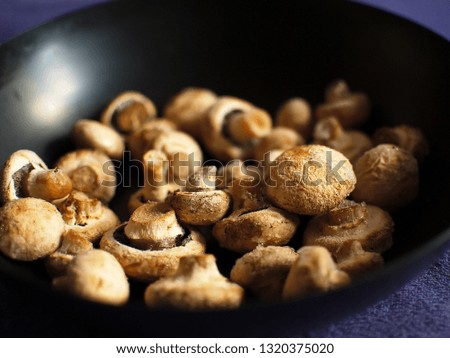 Mushrooms in hoarfrost. Frozen mushrooms in a skillet. Mushrooms in hoarfrost on a black skillet.