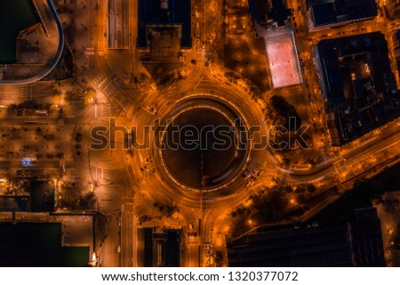 Night aerial photo of Roundabout next to port vellof Barcelona and road with car traffic. Aerial view drone pictures.