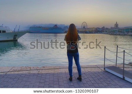 young woman on the pier taking a picture