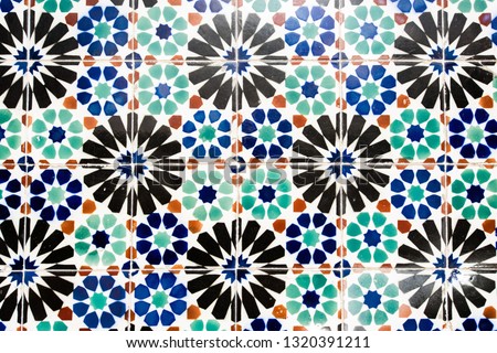 Old wall with traditional Portuguese decor tiles azulezhu in blue, black, red and green tones.