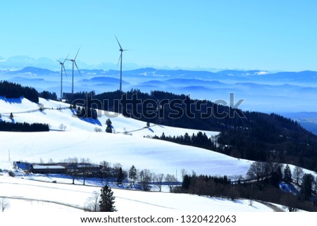 View to the swiss Alps. With three wind turbines in winterlandscape. Picture taken at Gersbach a district at Schopfheim south of Germany.
