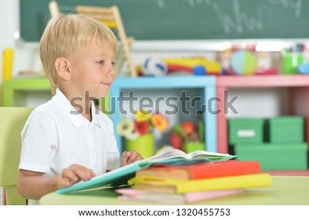 Portrait of cute little boy doing homework at home
