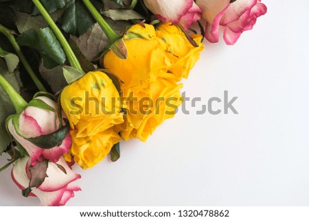 Floral festive background from a large bouquet of flowers. Delicate pink and sunny yellow roses on a white table. Love theme. Celebration.