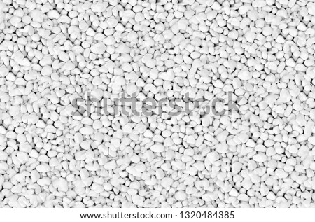 Clean White Pebbles texture. Small stones on the ground. Top view of Natural colorful gravel on the summer beach Royalty-Free Stock Photo #1320484385
