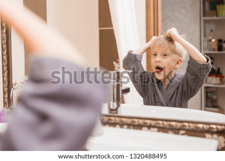 baby boy brushing his teeth and looking in the mirror.portrait of a smiling baby in Bathrobe after bathing.portrait of a smiling child with fallen milk teeth