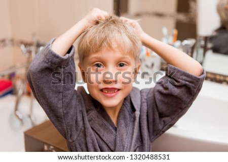 baby boy brushing his teeth and looking in the mirror.portrait of a smiling baby in Bathrobe after bathing.portrait of a smiling child with fallen milk teeth