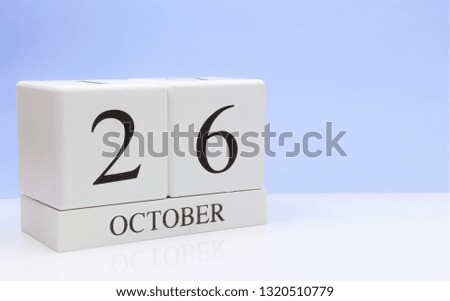 October 26st. Day 26 of month, daily calendar on white table with reflection, with light blue background. Autumn time, empty space for text
