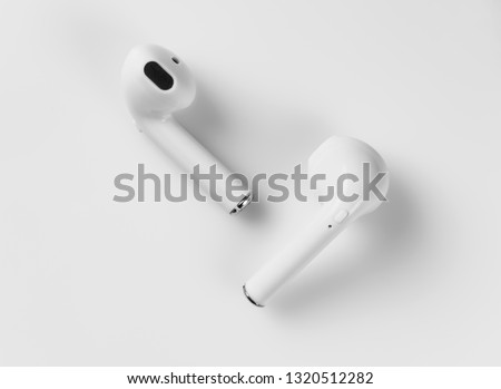 White wireless headphones are on a white background. Macro. Royalty-Free Stock Photo #1320512282