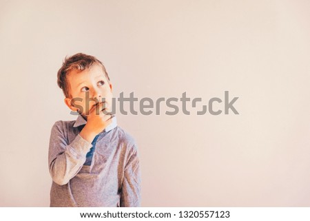 Thoughtful boy with doubts about his ideas, on white background with area copy space.