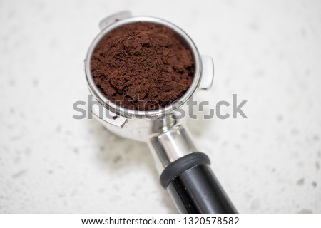  Barista presses ground coffee using tamper. color picture - Image
