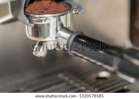  Barista presses ground coffee using tamper. color picture - Image