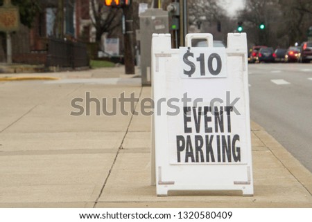 White Sign that says $10 Event Parking on sidewalk