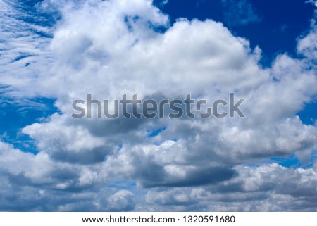 Fluffy  white cumulus clouds with some cumulostratus and cirrus formations on a summer afternoon  are contrasted against the  Australian sky creating a fascinating cloud scape.