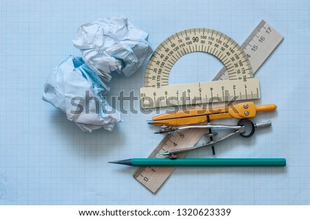 Mathematical instruments over the corner of a math graph paper with copy space for text. Math graphic tools concept