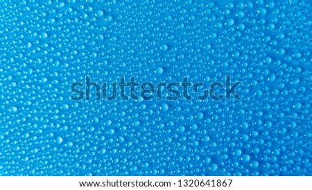 Many small drops of water on a blue background.