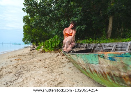 Woman sitting in a boat on the shore. 