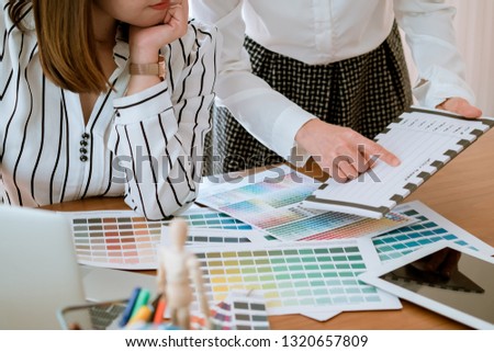 graphic designer working with computer and color swatch. creative man using digital tablet at modern office. Architect using work tools and sample colour catalog