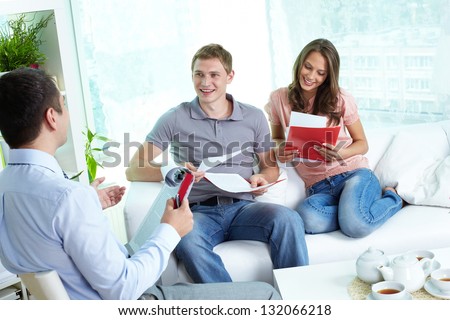 Young family reading insurance contract, their agent advising