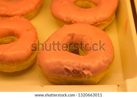 Donut in a shop of supermarket, under yellow light bulb