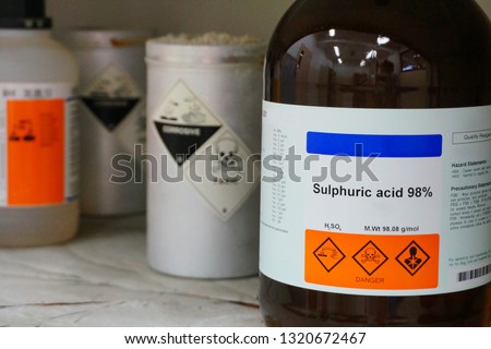 Bottle of Sulfuric Acid, H2SO4 with Properties information and its chemical hazard warning symbols. Corrosive hazard symbol, Inhalation hazard symbol and Toxic symbol Royalty-Free Stock Photo #1320672467