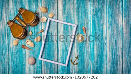 Top view on mock-up of white photo frame with vintage binoculars and seashells on blue wooden background with copy space