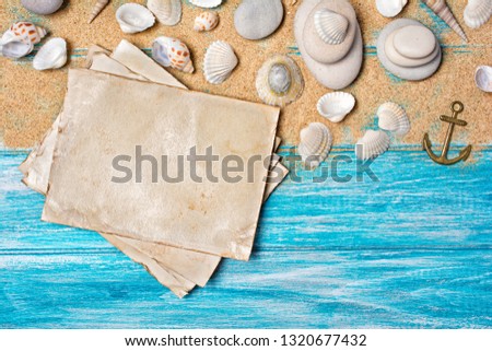 Top view on mock-up of vintage photo cards with sea stones and seashells on blue wooden background with copy space