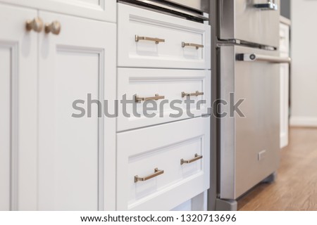 White kitchen built with shaker style cabinets. Shows cabinet details and brushed gold hardware knobs and pulls Royalty-Free Stock Photo #1320713696