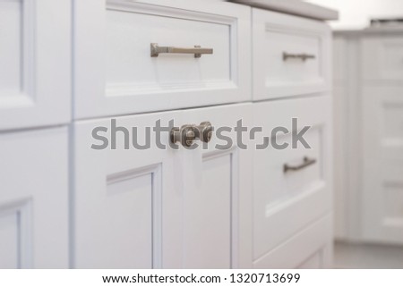White kitchen built with shaker style cabinets. Shows cabinet details and brushed gold hardware knobs and pulls Royalty-Free Stock Photo #1320713699